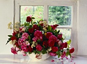 Bouquet of old roses in front of a window
