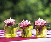 Three roses in decorated glasses