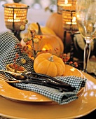 Herbstliches Gedeck mit gelben Tellern, Besteck & Kürbis