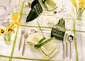 Festive table laid in green and white with yellow flowers