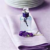 Bottle of violet water on violet napkin