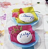 Plates with fabric napkins, flowers and painted stones