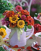 Yellow and red zinnias in jug (summery)