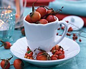 Autumnal table decoration: rose hips in coffee cups