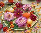 Summer flowers and floating candles on pale green plate
