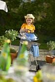 Child lifting the lid of a barbecue