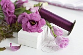 Decorating a gift box with lisianthus and twine