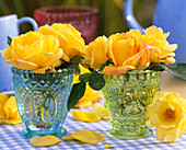 Yellow roses in blue and green cut glass vases