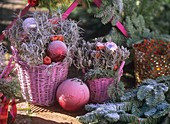 Pink baskets with Christmas decorations with hoar frost