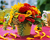 Arrangement of zinnias & sunflowers, yellow chillies beneath