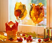 Wine glasses wrapped with autumn leaves and wire