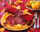 Yellow plate with red napkin, and vine leaf