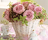 Pink roses, Pittosporum and hydrangeas in white basket