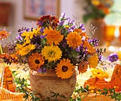 Vase of marigolds and sea lavender