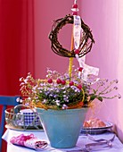Table decoration with forget-me-nots and wreath of twigs