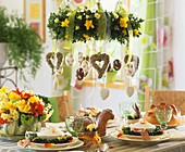 Table laid for Easter with soup bowls; hanging wreath