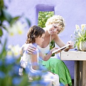 Woman and child reading at garden table