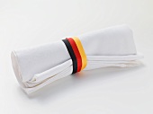 White fabric napkin with ribbon in colours of German flag