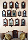 A collection of wall clocks above a sofa