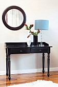 Black side table with table lamp and vases