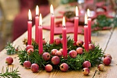 Weihnachtskranz aus Eibe mit Zieräpfeln und acht roten Kerzen