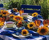 Garland of sunflowers and tea things on garden table