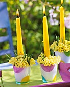 Glasses filled with cowslips & grasses used as candle holders