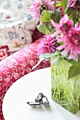 Summery floral decoration on a side table next to a sofa
