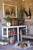 A terrace with plants, pictures and antlers