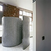 Geflieste Wand in Schneckenform als WC-Abtrennung in offenem Loft-Bad