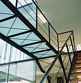 Offene Stahltreppe mit Holzstufen und Steg mit Mattglasboden