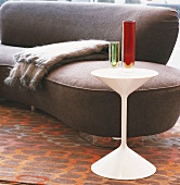 Gerundetes zeitgenössisches Designer Sofa und 50er Jahre Glasvasen auf weißem Beistelltisch im 70er Jahre Stil