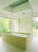 Aufgeglastes Designer-Bad im minimalistischen Stil mit umbauter Wanne und begehbarer Dusche