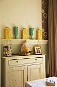 White, vintage-style cabinet and ornamental vases