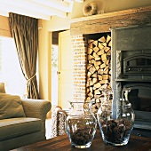 Rustikales Wohnzimmer mit aufgestapeltem Brennholz und Backsteinwand