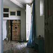 Rustic foyer with linen curtain, wood-beamed ceiling and old wooden door