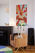 Colourful painting, leather armchair and standard lamp with bendable tube in corner of room