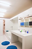 White bathroom with sparing accents of colour and sliding door