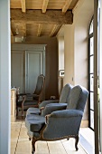 Antique blue armchairs in front of French windows