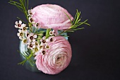 A spring bouquet with pink buttercups in a vase