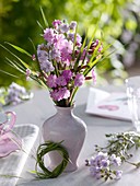 Posy of spring flowers and small wreath of grass (table decoration)