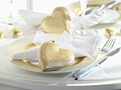 Place-setting for special occasion with gold hearts and gold-rimmed plate