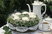 Green & white spring arrangement in shape of cake, coffee things