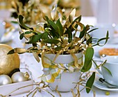 Table arrangement of gold and green mistletoe