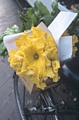 Courgette flowers in a wooden crate on a bicycle
