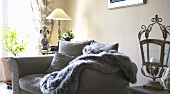 A sofa with a furry blanket and cushions