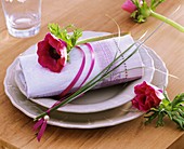 Place-setting with poppy anemone and bear grass on napkin