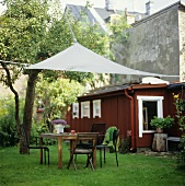 Garden table with chairs and awning out of doors