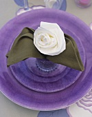 Place-setting with napkin folded into rose shape