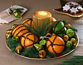 Oranges and limes studded with cloves, fir sprigs & candle